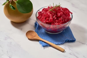 chucrut de col morada en un bol con una cuchara de madera