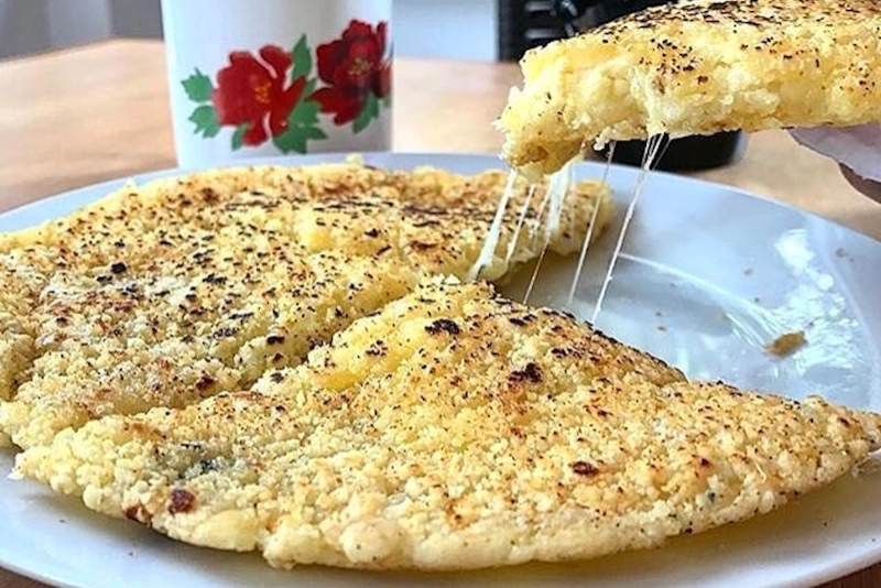 mbeju de almidón de mandioca dorado y crujiente en un plato blanco