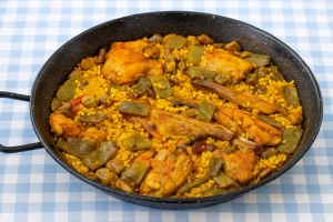 deliciosa paella valenciana con pollo dorado y conejo