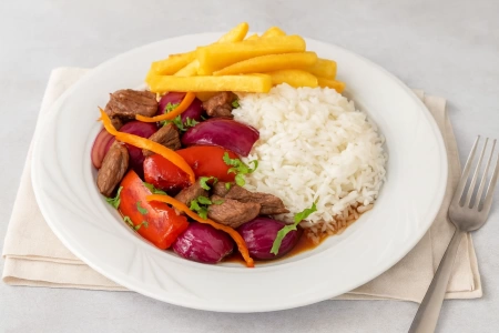 Lomo saltado peruano con arroz y papas fritas