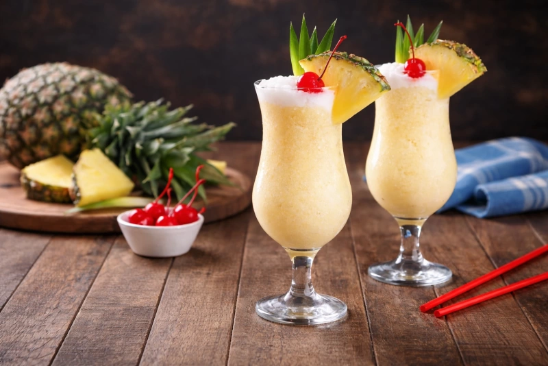 Deliciosa piña colada cremosa y refrescante en dos  copas tipo huracán